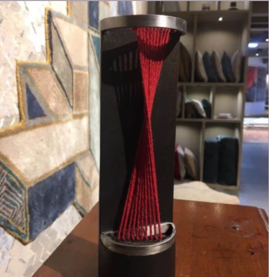 Totem sculpture with red thread detail