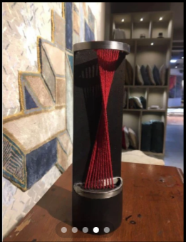 Totem sculpture with red woven yarn at Jaipur Rugs